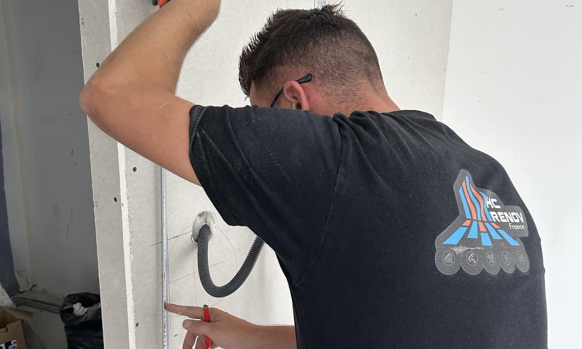 Electricien de dos prenant des mesures